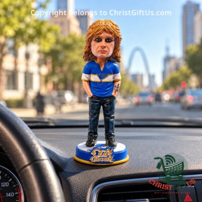 Ozzy Osbourne Blues bobblehead on a car dashboard with the Gateway Arch